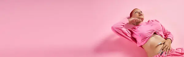 Esta joven confiada muestra su sentido único de la moda en un estudio elegante con acentos rosados. - foto de stock