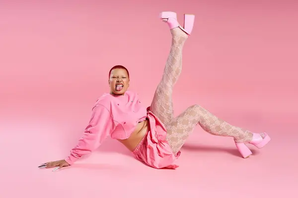 A young woman boldly expresses her fashion style while posing playfully in a vibrant studio setting. — Stock Photo