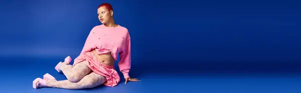 This confident young woman displays her unique fashion sense with bold colors and striking accessories in a studio. — Foto stock