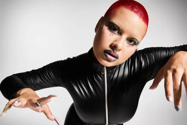 Una joven con el pelo corto de color rosa muestra su sorprendente sentido de la moda en un ambiente de estudio creativo. — Stock Photo