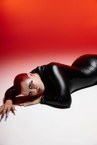 Showcasing unique fashion, a young woman with pink hair lies confidently on a studio floor, striking a pose. — Stock Photo