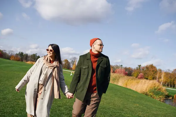 A loving couple enjoys a cozy walk together in a picturesque autumn landscape. — Stock Photo