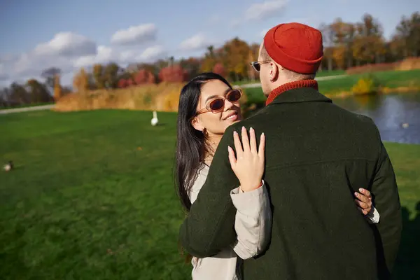 A joyful couple enjoys a pleasant autumn day, embracing each other surrounded by colorful trees. — Stock Photo