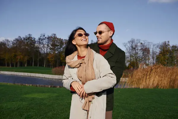 A warm hearted couple enjoys each others company in vibrant autumn attire under a clear sky. — Stock Photo