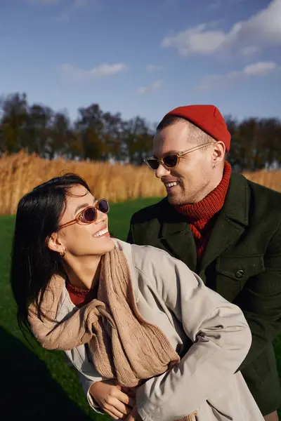 A couple shares laughter and warmth outdoors, celebrating the beauty of autumn together. — Stock Photo