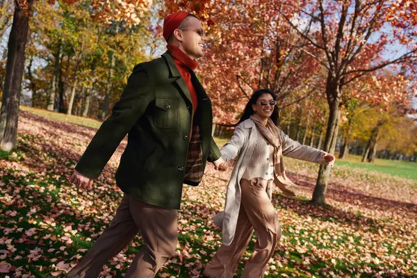 A loving couple walks together in a beautiful autumn park, surrounded by colorful leaves. — Stock Photo