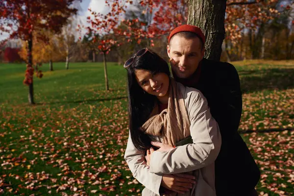 A loving couple enjoys a tender moment outdoors amid colorful autumn leaves. — Stock Photo