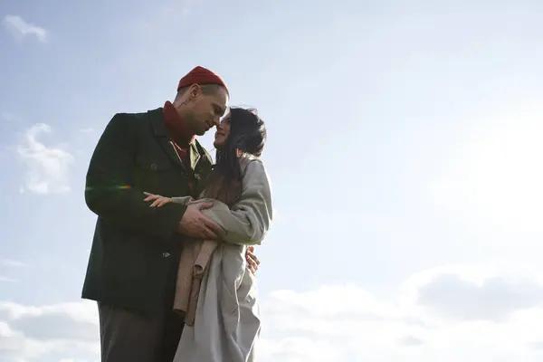 A loving couple shares a tender moment in warm clothing against a beautiful autumn backdrop. — Stock Photo