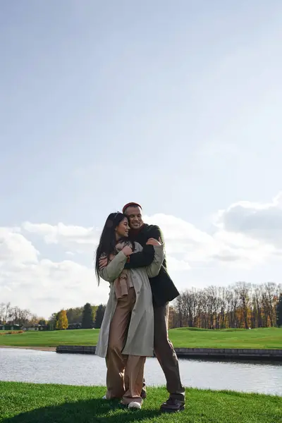 A couple joyfully embraces in autumn clothing, surrounded by natures beauty and serenity. — Stock Photo