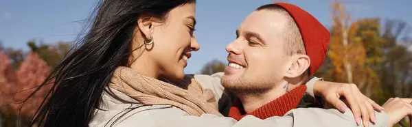 A couple embraces warmly in autumn layers, enjoying each other company amidst vibrant leaves. — Stock Photo