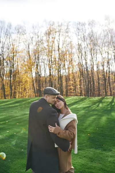 A couple embraces warmly, surrounded by vibrant autumn foliage in a serene landscape. — Stock Photo