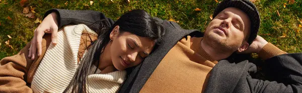 Un couple partage un moment tendre, enveloppé de couches chaudes, entouré de feuilles d'automne. — Photo de stock