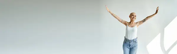A young bald woman joyfully poses in a bright, airy space, embracing her uniqueness. — Stock Photo