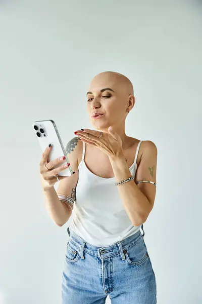 A bald young woman radiates confidence as she checks her phone and poses playfully. — Stock Photo