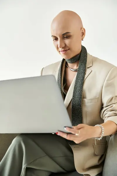 A confident bald woman with alopecia focuses on her laptop, exuding grace and poise. — Stock Photo
