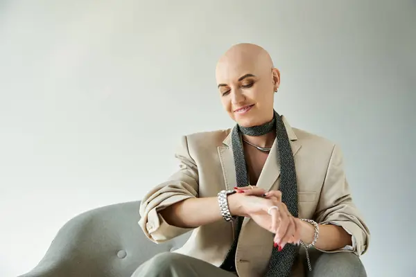 A bald woman with alopecia smiles stylishly as she checks the time. — Stock Photo