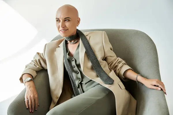 A young woman with alopecia radiates confidence, dressed elegantly and seated comfortably. — Stock Photo