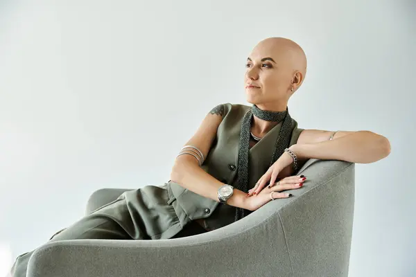 Una joven con alopecia irradia confianza mientras descansa con gracia en una silla moderna. — Stock Photo