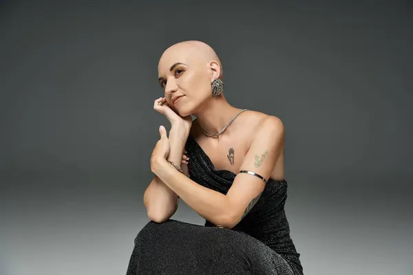 A young bald woman showcases her elegance and strength in a graceful pose, emphasizing her identity. — Stock Photo