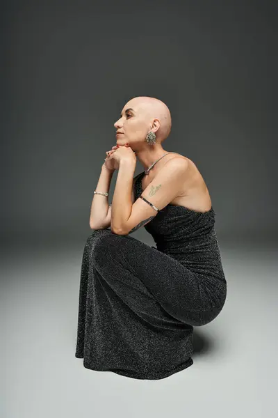 A young woman with alopecia sits gracefully, deep in thought, showcasing her unique beauty. — Stock Photo