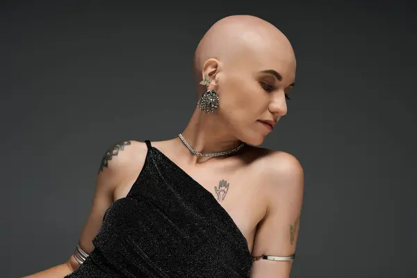 The young woman exudes confidence with her bald head and striking tattoos, wearing a stylish outfit. — Stock Photo
