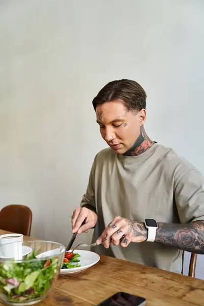 A handsome young man focuses on his nutritious meal at home, savoring each bite. — Stock Photo
