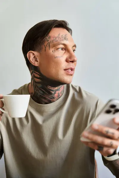 A young man enjoys his coffee at home, focused on his smartphone in a relaxed morning. — Stock Photo
