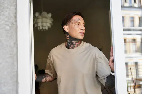 A young man stands in the doorway, radiating a relaxed vibe while embracing his unique style. — Stock Photo