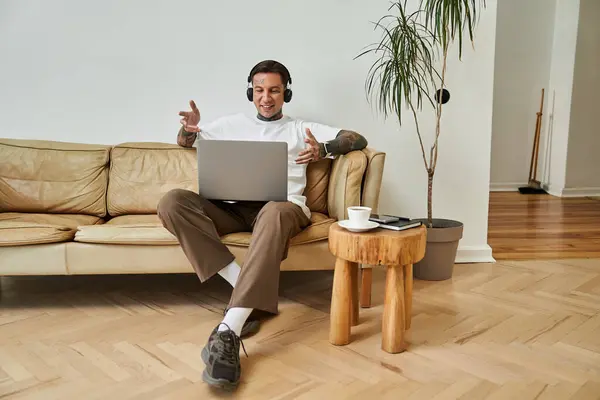The young man engages in a lively conversation during a video call at home. — Stock Photo