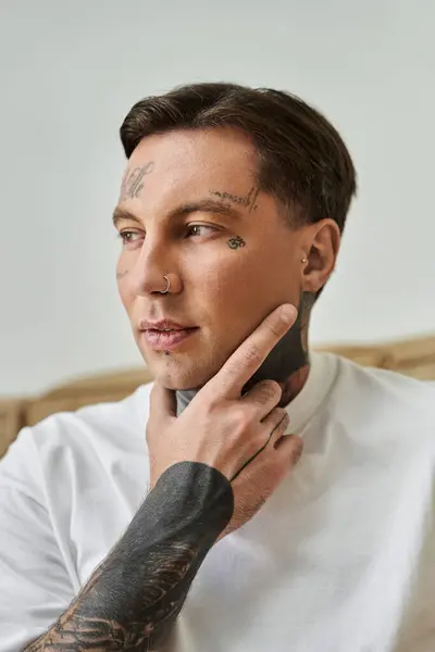 The handsome man with tattoos reflects deeply, enjoying his tranquil home atmosphere. — Stock Photo