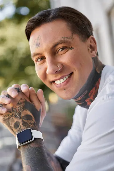 A handsome man with tattoos relaxes at home, showing his joyful personality and style. — Stock Photo
