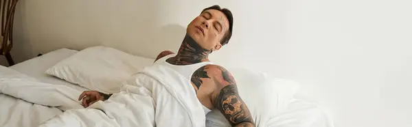 A young handsome man unwinds peacefully in his tidy bedroom as morning light floods in. — Stock Photo