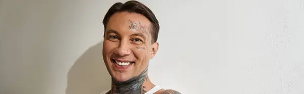 This young man enjoys a carefree moment at home, exuding charm and confidence with tattoos. — Stock Photo