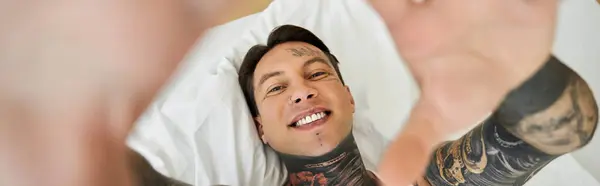 A cheerful young man at home enjoys a moment of relaxation and connection with the camera. — Stock Photo