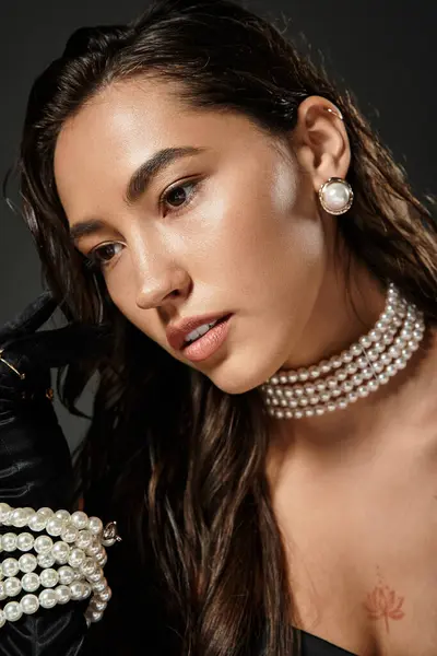 A sophisticated young woman showcases timeless elegance with pearl jewelry and graceful attire. — Stock Photo