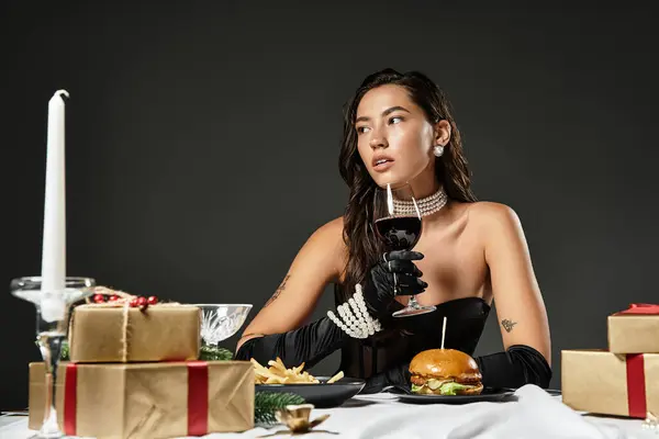 A young woman dressed elegantly savors a gourmet meal surrounded by decorations. — Stock Photo