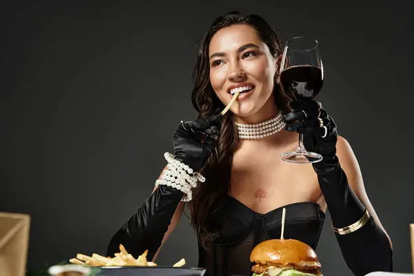 A sophisticated young woman indulges in fine dining while dressed elegantly. — Stock Photo