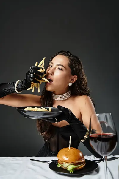 Diese elegante Frau genießt Pommes in stilvoller Kleidung und präsentiert Raffinesse. — Stockfoto