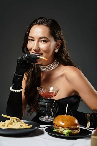 Eine stilvolle Frau in eleganter Kleidung genießt Gourmet-Essen und einen Cocktail bei einem verschwenderischen Treffen. — Stockfoto