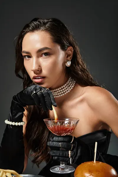 A young woman in elegant attire savors a cocktail, exuding confidence and sophistication. — Stock Photo