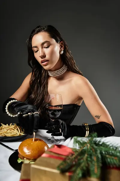 Eine elegant gekleidete junge Frau genießt ihr Gourmet-Menü und ihren Wein mit ausgeglichenem Auftreten. — Stockfoto