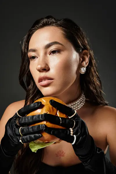A young woman dressed elegantly contemplates her gourmet burger, showcasing sophisticated style. — Stock Photo
