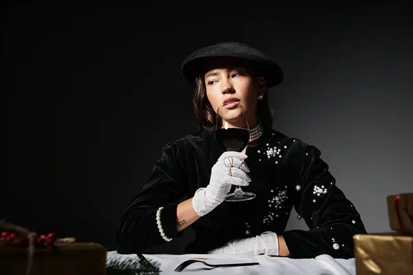 Uma mulher elegante em uma roupa preta saboreia vinho pensativo em uma mesa lindamente arranjada. — Fotografia de Stock