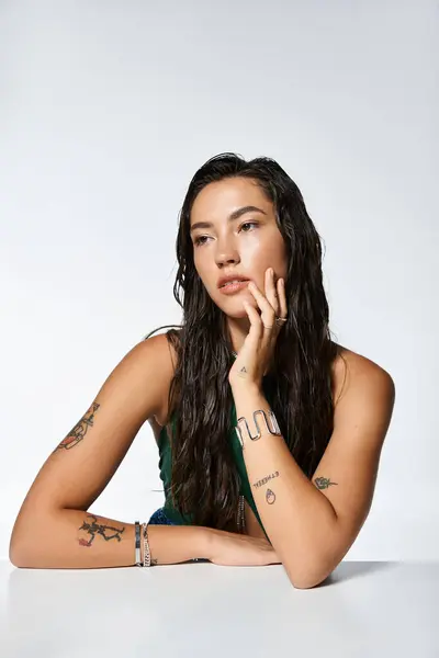 A sophisticated woman displays her unique style with elegant attire and artistic tattoos. — Stock Photo