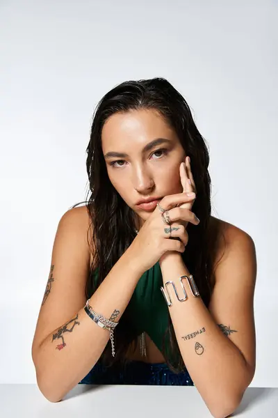 A stylish young woman with tattoos exudes elegance and poise with a calm expression. — Stock Photo