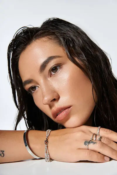 Une belle femme pose gracieusement, mettant en valeur ses superbes bijoux d'une manière artistique. — Photo de stock