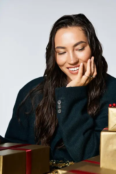 Une jeune femme au sourire éclatant dévoile des cadeaux au milieu d'un décor magnifique. — Photo de stock