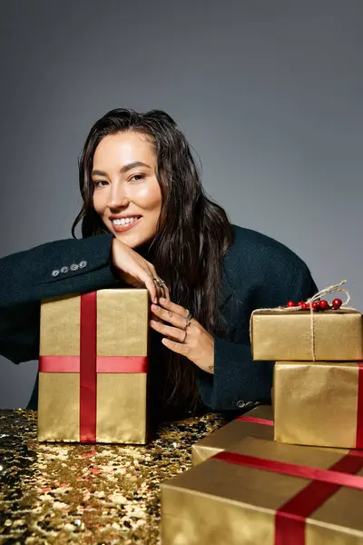 A sophisticated woman with a warm smile engages with festive gifts in an elegant setting. — Stock Photo