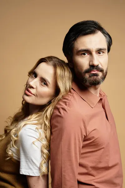 Two middle aged people share a warm, intimate moment against a soft backdrop. — Stock Photo