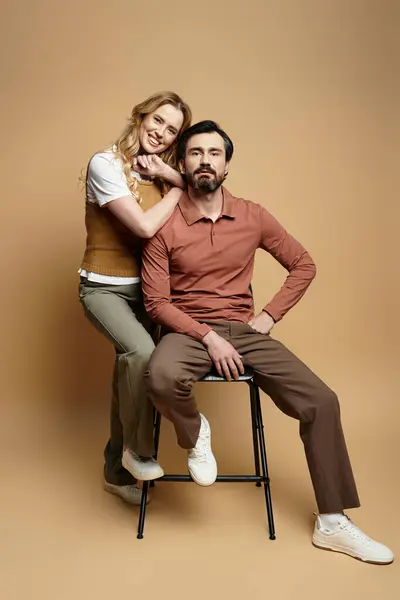 A joyful middle aged couple is playfully posing in a modern studio with a warm backdrop. — Stock Photo